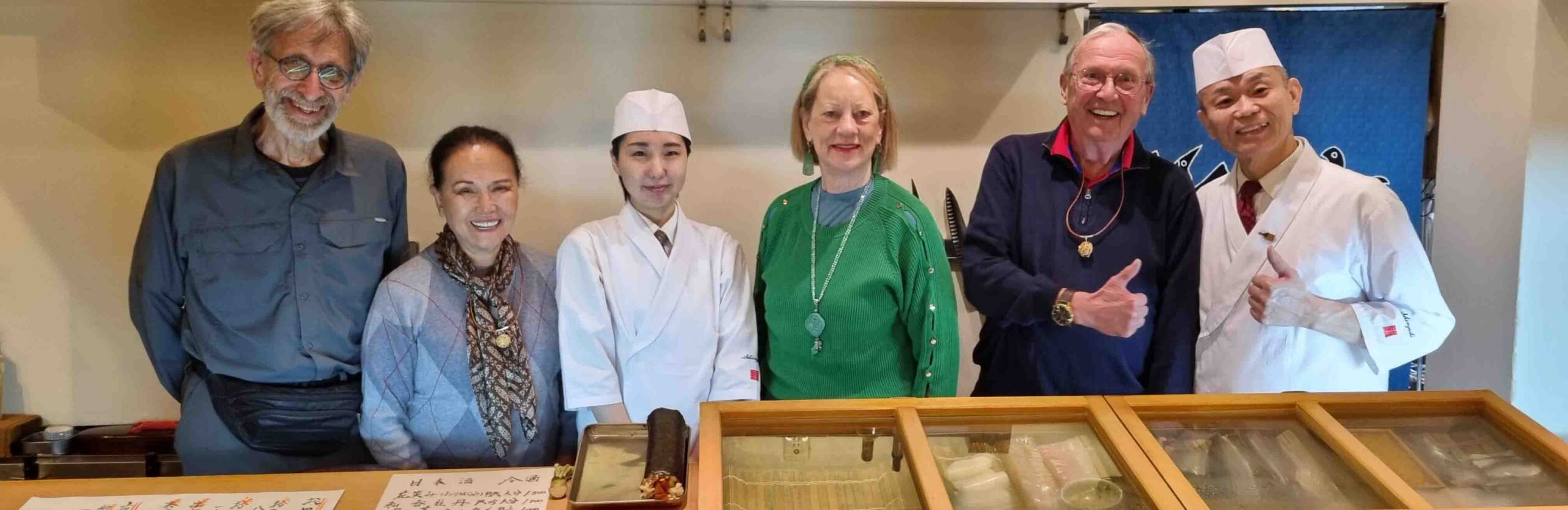 Travelers and chefs at a sushi restaurant in Beppu