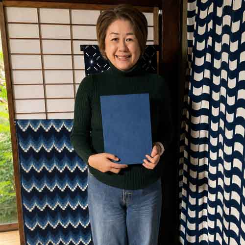 Yumiko Ichinose, a staff member of Journey to the East holding an indigo cloth panel in Yame, Fukuoka Japan