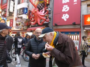 Eating Takoyaki (octopus ball), a typical Osaka snack